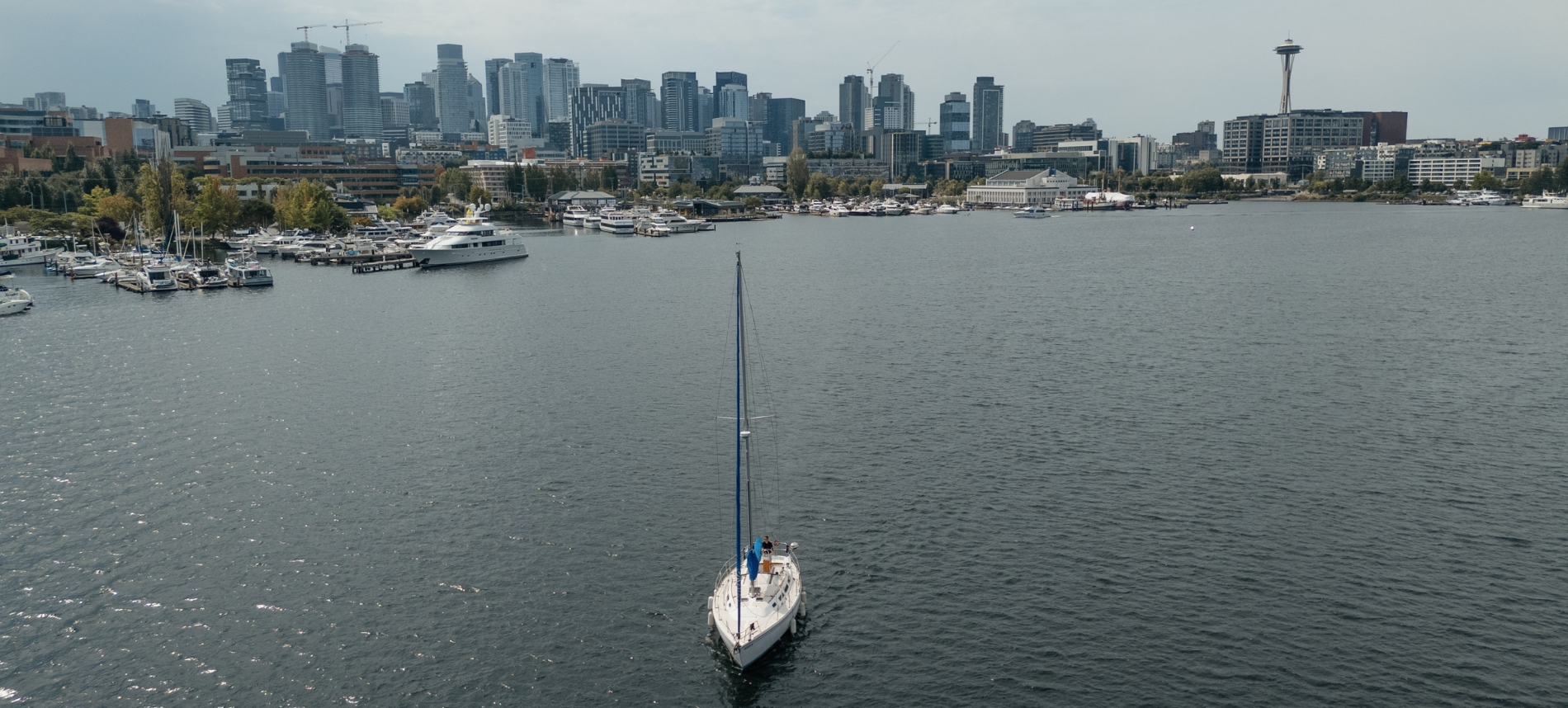 A sailboat in the Puget Sound with the city of Seattle stretching out beyond, home of Northlake Wealth Advisors